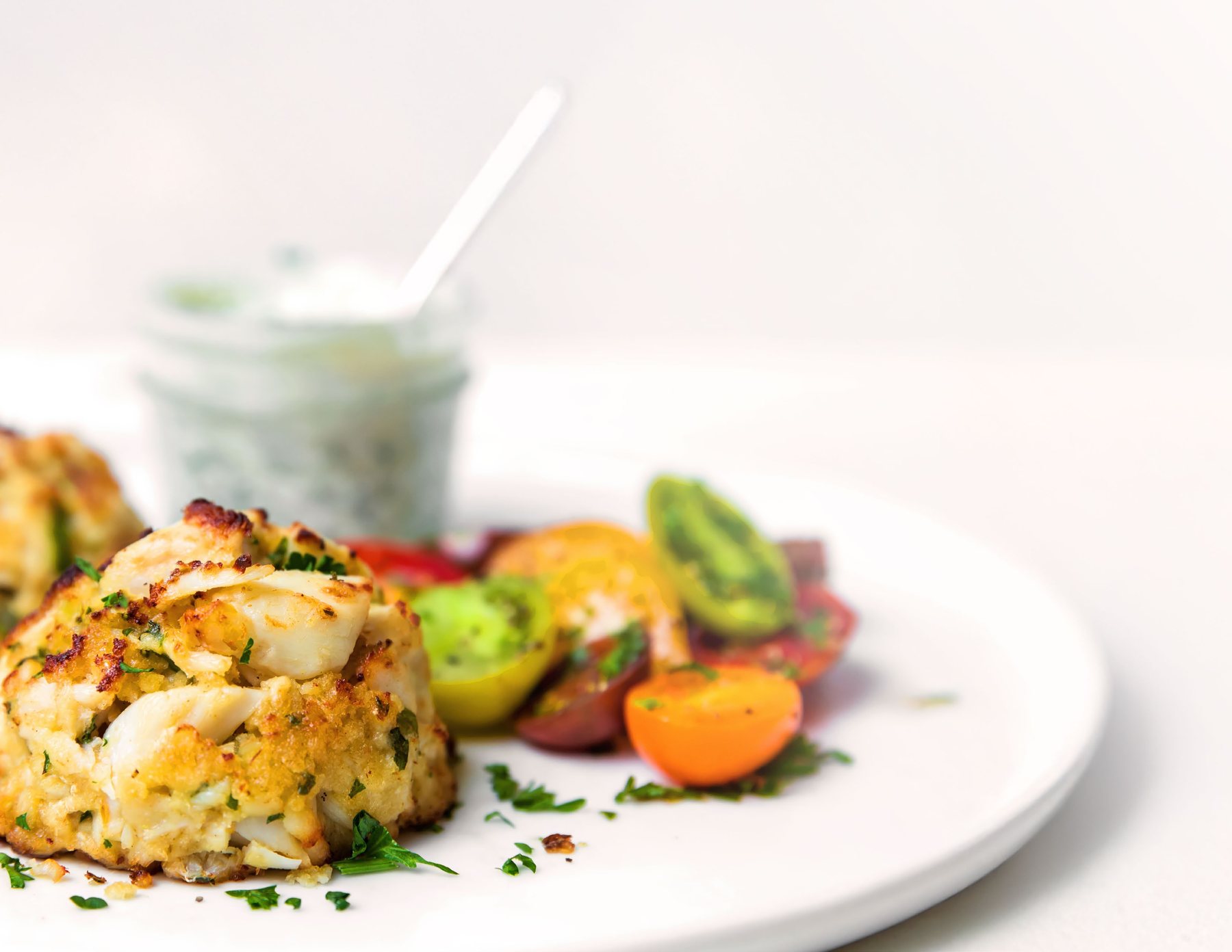 Jumbo lump crab cake with tomato salad and herb sauce
