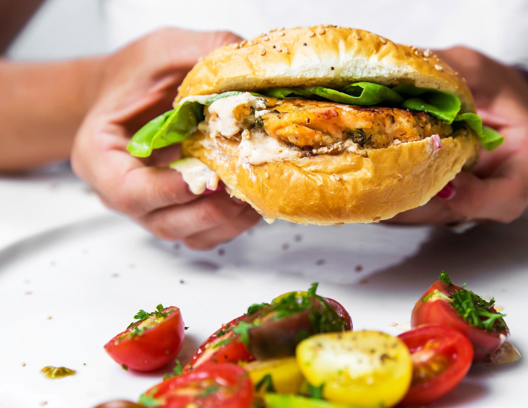 Salmon cake sandwich on a seeded bun